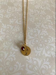 "Lovely and meaningful January birth month snowdrop flower necklace. Stainless steel gold color small disc with snowdrop imprint and red garnet color January birthstone charm addition. Flower charm measures 5/8\" in diameter and is on an 18\" chain. Also available in stainless steel silver color under the following listing: https://www.etsy.com/listing/1209259907/january-birth-month-flower-necklace?ref=listings_manager_grid ★ Want to see more? Please visit my shop at: https://www.etsy.com/shop/D January Birth Month Flower, Snowdrop Flower, January Birthstone Necklace, January Birth Flowers, Garnet Color, January Birthstone Jewelry, Birth Flower Necklace, Garnet And Gold, Birth Month Flower