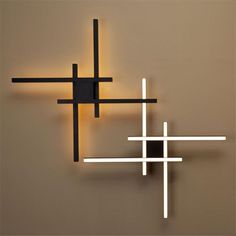 a wall mounted light that is on the side of a wall with two crosses in it