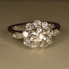 an old cut diamond ring with three pear shaped diamonds on the sides and two smaller pear shaped diamonds on the side