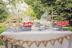 a table topped with lots of desserts on top of a blue and white table cloth