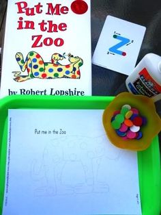 the children's book put me in the zoo by robert lopshire is displayed on a green tray