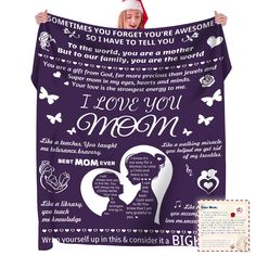 a woman holding up a purple blanket with the words i love you mom on it