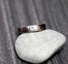 a silver ring sitting on top of a rock