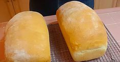 two loafs of bread sitting on top of a cooling rack next to each other