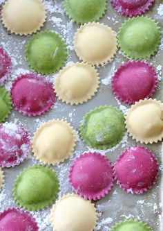 colorful pastries on a baking sheet covered in powdered sugar