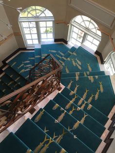 an aerial view of a staircase with fish painted on the carpet and windows in the background