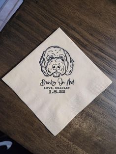 a napkin with a dog's head on it sitting on top of a wooden table