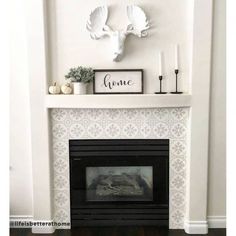 the fireplace is decorated with white and black decor, including two deer heads on top