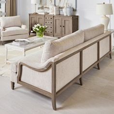 a living room with two couches, chairs and a coffee table in front of a mirror