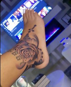 a person with a rose tattoo on their arm and foot in front of a television