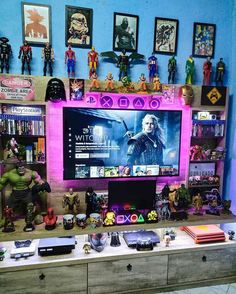 a tv sitting on top of a dresser next to a shelf filled with action figures