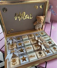 a teddy bear sitting on top of a wooden box filled with gold and silver stars