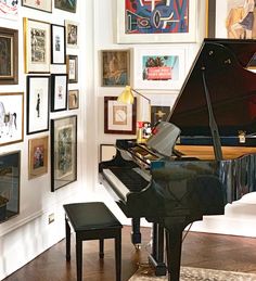 there is a piano in the room with many pictures on the wall