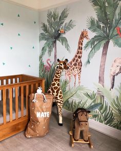 a baby's room decorated with giraffes and palm trees