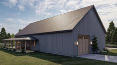 a large gray barn sitting on top of a lush green field