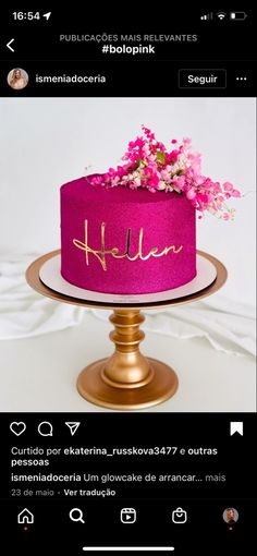 a pink cake sitting on top of a gold plate covered in frosting and flowers