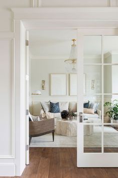 a living room filled with furniture and a large mirror on the wall above it's door