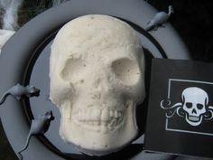 a white skull sitting on top of a black plate