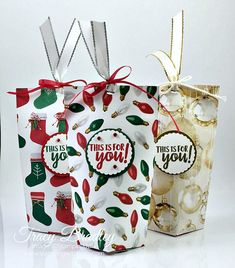 three christmas gift bags with tags on them