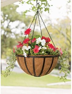 a hanging planter filled with red and white flowers