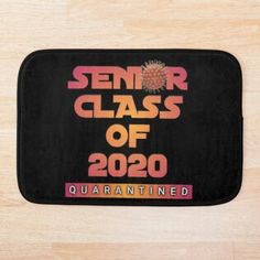 a black mat with the words senior class of 2020 printed in pink and orange on it