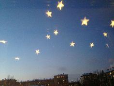 stars are flying in the sky above buildings