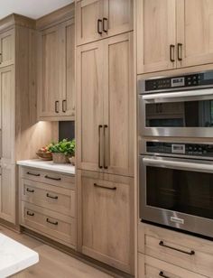 a large kitchen with wooden cabinets and stainless steel appliance, including an oven