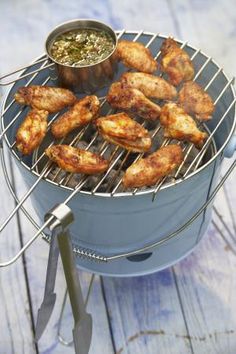 chicken wings are being cooked on the grill