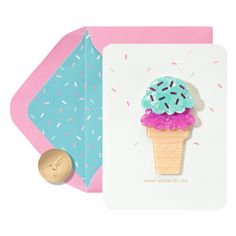 an ice cream cone with sprinkles on it sits next to a pink envelope