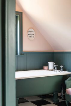 a bathroom with a checkered floor, tub and clock on the wall above it