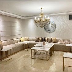 a living room filled with lots of furniture and a chandelier hanging from the ceiling