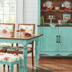 a dining room table and chairs with plates on the china cabinet in the back ground