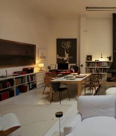 a living room filled with furniture and bookshelves next to a fire place on the wall