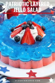 patriotic layered jello salad with strawberries and blueberries in the middle on a white plate