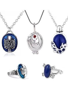 four different rings and pendants with blue stones on the front, one in silver