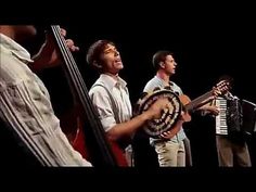 three men are playing musical instruments on stage