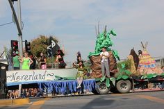 a float with people standing on the back of it's sides in a parade