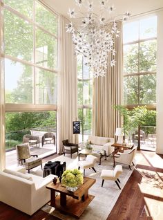 a living room filled with furniture and a chandelier hanging over the top of it