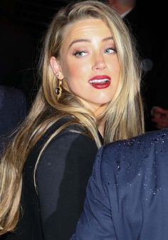 a woman with long blonde hair and red lipstick