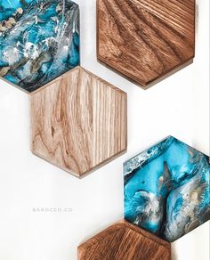 three wooden hexagonals with blue and brown marble designs on them, hanging from the wall