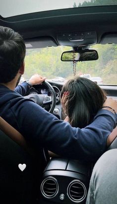 two people sitting in the driver's seat of a car with their backs to each other