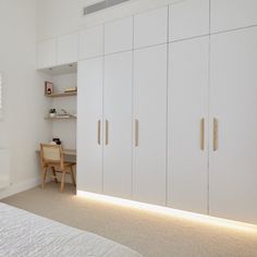 a bedroom with white cupboards and a bed