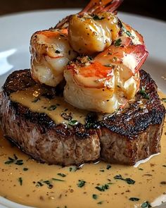 a steak with shrimp and sauce on it