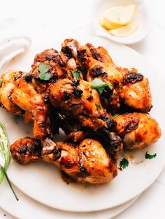 a white plate topped with chicken wings and garnish