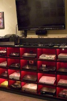 a large entertainment center with many video game consoles in front of a flat screen tv