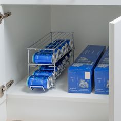 blue cans are stacked on top of each other in a shelf next to some boxes