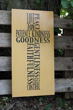 a wooden cross with the words love, joy and patient kindness written on it in different languages