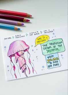 a drawing of a jellyfish and some colored pencils on a white surface next to it