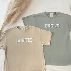 two t - shirts with the words uncle and aunte on them next to some feathers