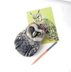 an owl with a crown on its head sitting next to a pencil